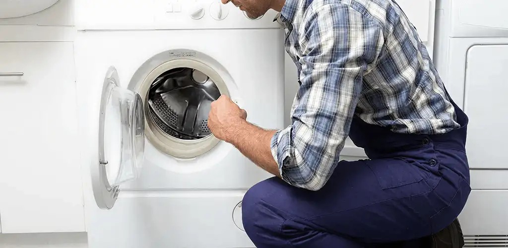 Handyman inspecting a dryer drum and internal parts for repair in Charleston, SC