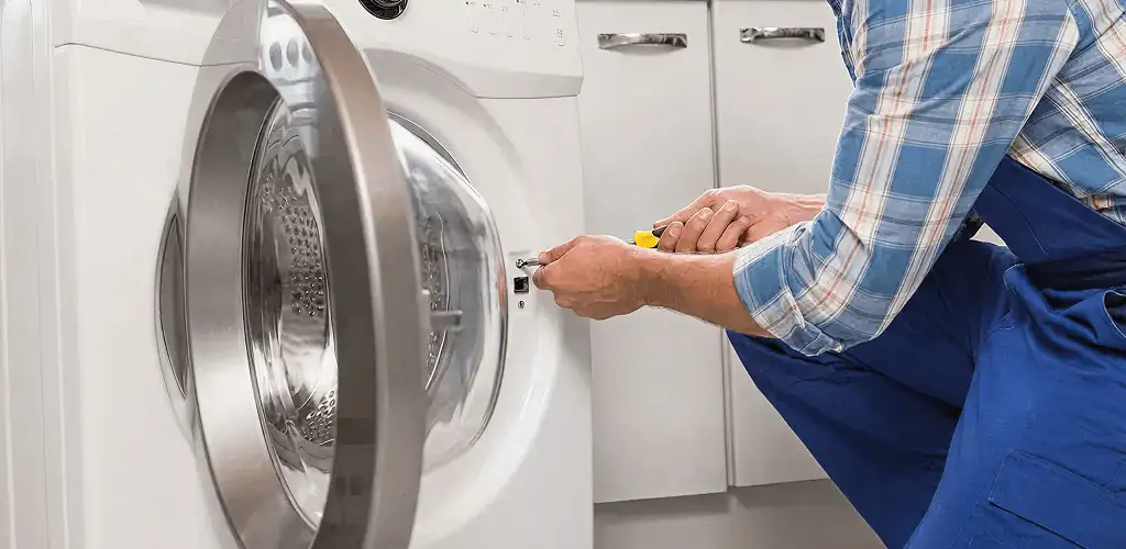 Handyman repairing a clothes dryer and checking electrical connections in Charleston, SC
