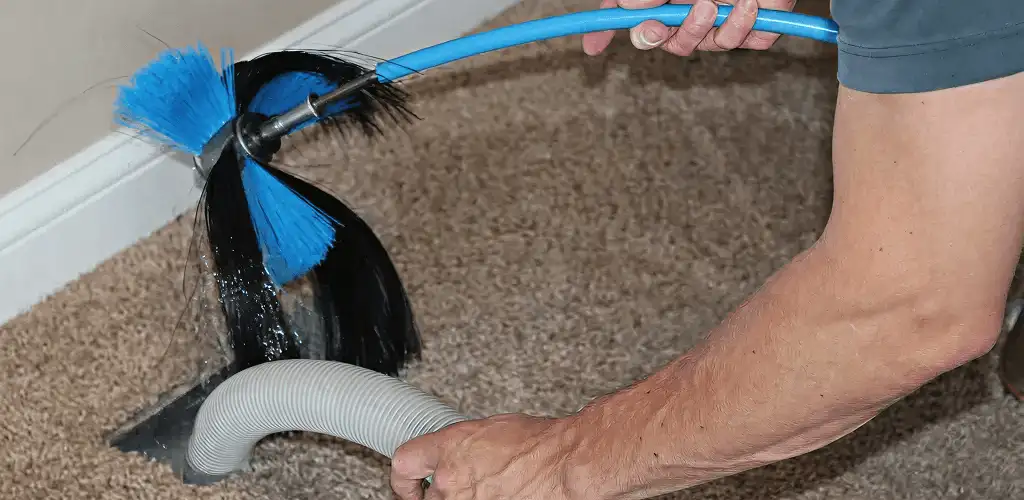 Dryer vent cleaning technician brushing lint from a vent line in Charleston, SC