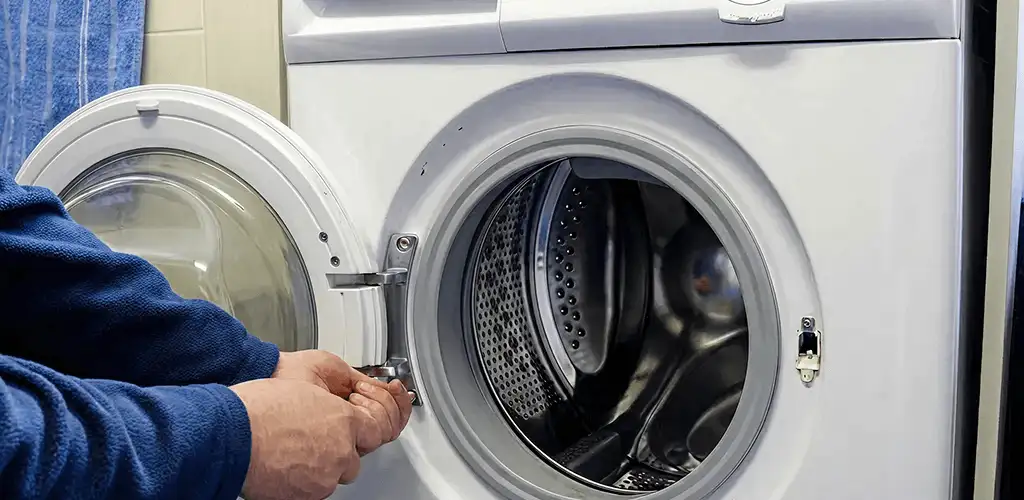 Washing machine repair handyman checking a front-load washer door and latch in Charleston, SC