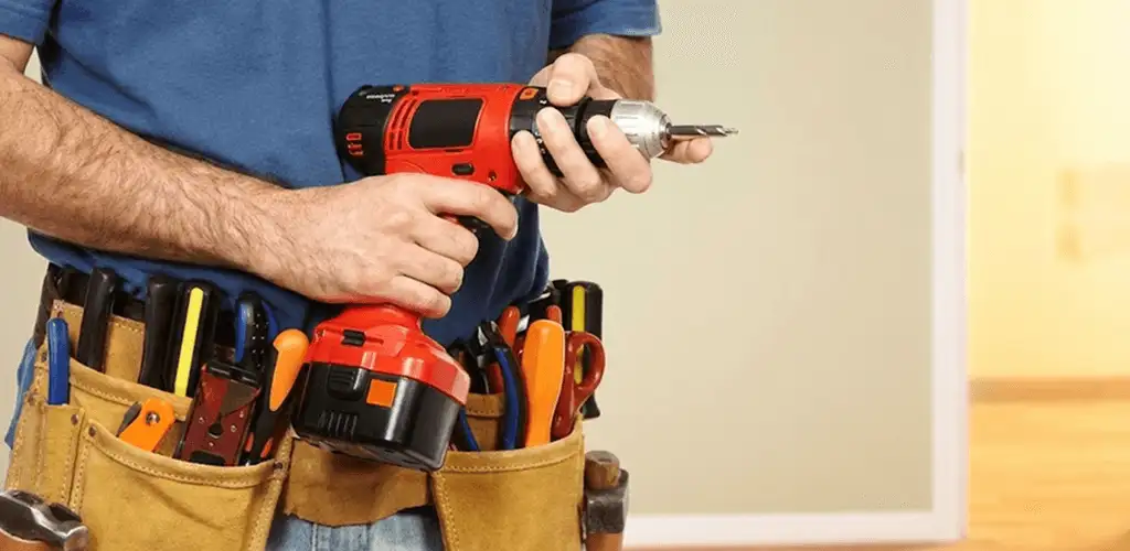 Handyman holding a power drill for home repairs and installations in Charleston, SC