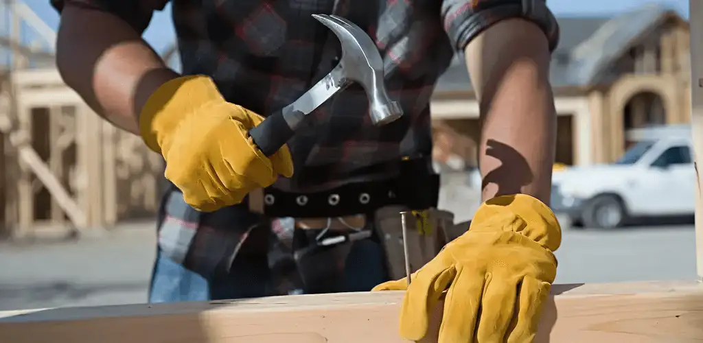 Handyman fixing wood trim with a hammer for home repairs in Charleston, SC