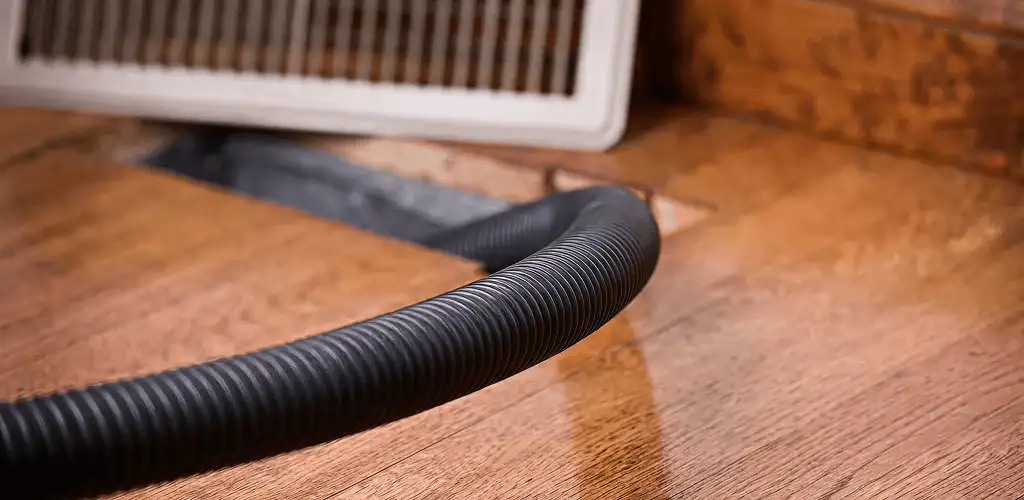 Air duct cleaning hose inserted into a floor vent for ductwork cleaning in Charleston, SC