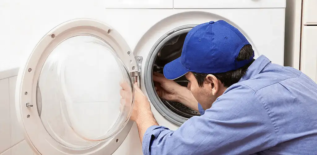 Washing machine repair handyman inspecting a front-load washer drum in Charleston, SC