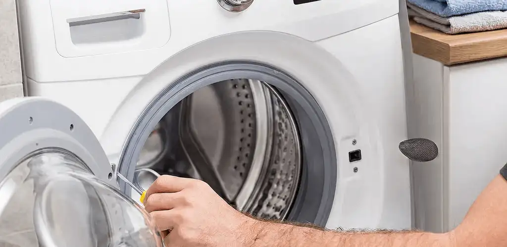 Handyman repairing a front-load washing machine and inspecting the drum in Charleston, SC