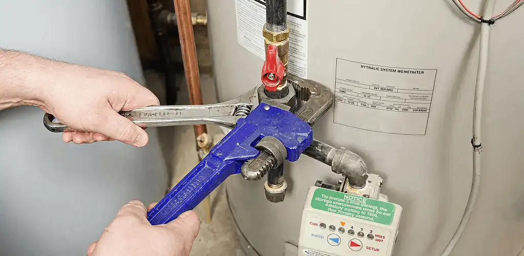 Water heater repair technician tightening the shutoff valve and supply line in Charleston, SC